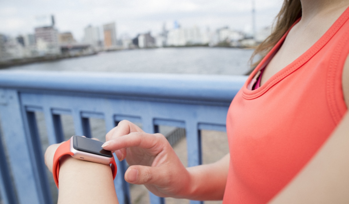 Woman checking time on smart watch during run
