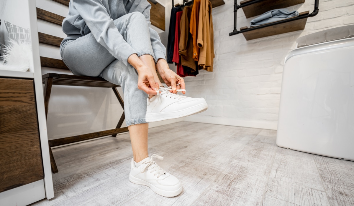 Woman wearing white sneakers in the wardrobe